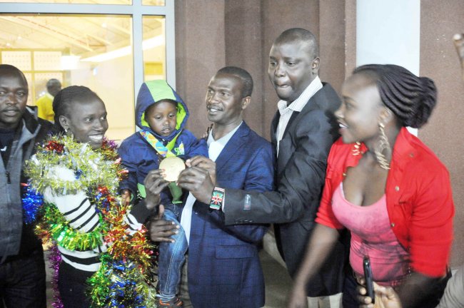 Vivian Cheruiyot with husband Kiplagat Kipkurui and friends shows her medals. President Kenyatta has promised the government will honor their promise of rewarding athletes. (Photo by Shutterspeed).